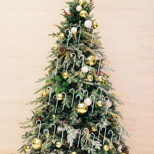 Close-up of glittery acrylic candy cane ornaments hanging on a decorated Christmas tree