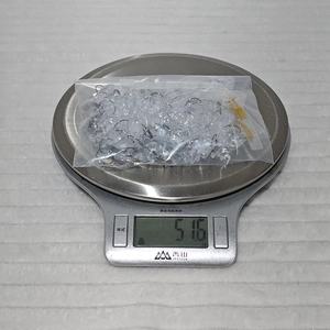 Detailed view of clear acrylic icicle ornaments on a scale weighing 51.6 grams