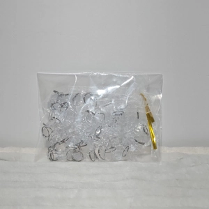 Bulk silver metal jump rings in a white organza bag and clear plastic packaging