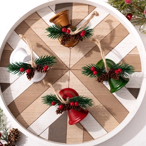 Christmas bell ornaments in red, green, gold, and white with pine cones and jute ropes