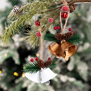Rustic Christmas bells with pine cones and red berries hanging on a cedar tree branch