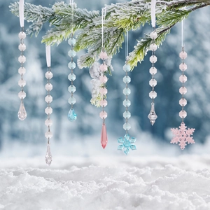 Clear acrylic Christmas ornaments with snowflake and icicle pendants on snowy pine branches