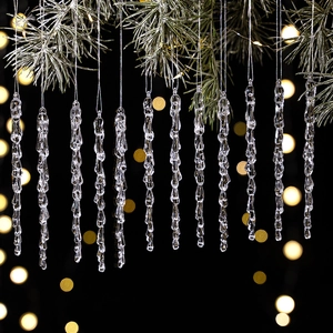 Macro detail of clear acrylic icicle ornaments hanging on a festive Christmas tree branch