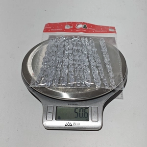 Detail showing weight of acrylic Christmas icicle ornaments in transparent plastic packaging