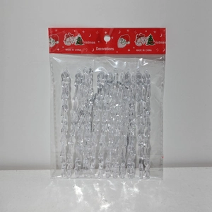 Detail of transparent acrylic icicle ornaments in packaging with festive red cards