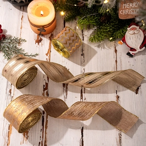 Detail of burlap Christmas ribbons with gold trim on a rustic wooden surface decoration
