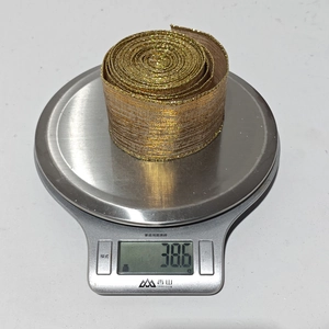 Detailed shot of golden glitter mesh ribbon on a kitchen scale showing 38.6g weight