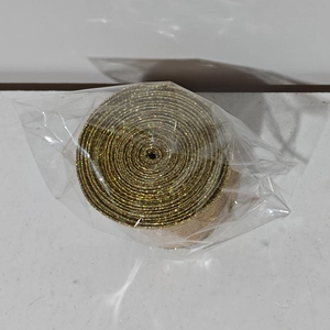 Macro shot of glittery gold burlap ribbon roll for Christmas DIY gift wrapping decoration
