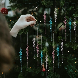 Close-up of spiral acrylic icicle ornaments in pink and blue on a Christmas tree