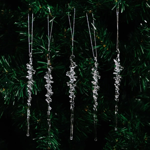 Macro detail of five transparent acrylic icicle ornaments hanging on a Christmas tree