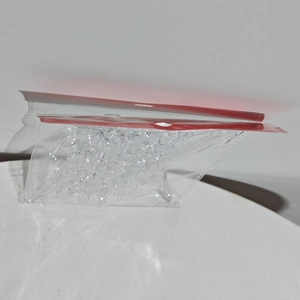 Macro shot of clear acrylic Christmas icicle pendants in a sealed storage bag
