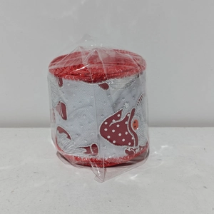Close-up of Christmas ribbon roll with red gnome prints and star patterns on silver base