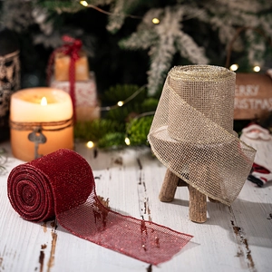 Close-up of red and gold glitter mesh ribbons on a festive wooden surface for DIY crafts