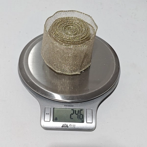 Detail shot showing 246g weight of gold mesh decorative ribbon on a scale