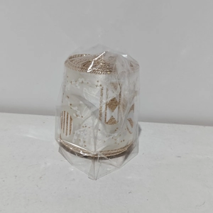 Close-up of white Christmas ribbon roll with gold snowflake prints in clear packaging
