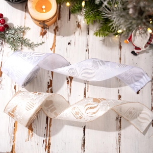 Silver and gold Christmas tree ribbons with glitter patterns on a rustic wood surface