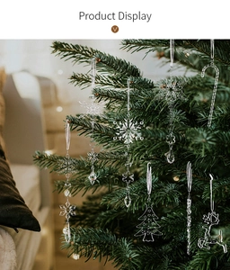 Detailansicht klarer Acryl-Eiszapfen und Schneeflocken an einem grünen Weihnachtsbaum