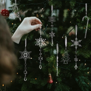 Detailansicht von klaren Acryl-Weihnachtsanhängern an einem beleuchteten Tannenbaum