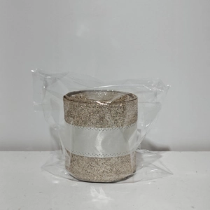 Sparkling gold Christmas ribbon with glitter finish in protective plastic wrap