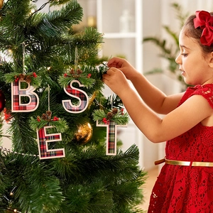 Detail of red and green plaid wooden Christmas letters B E S T with pine needle decor