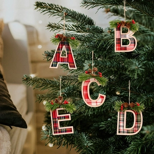 Detailed view of A to E Christmas tree letter pendants with red plaid and pine cone accents
