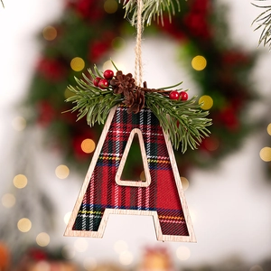 Close-up of wooden letter A Christmas tree ornament with red plaid and pine needles