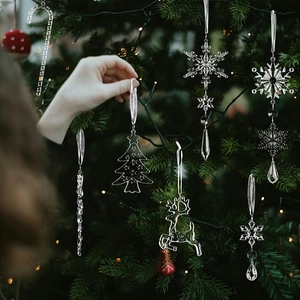 Vue détaillée de suspensions de Noël en acrylique transparent décorant un sapin de fête