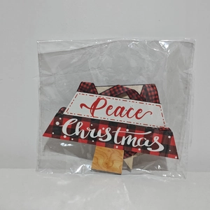 Détail de l'ornement de Noël Peace en bois avec bordure à carreaux rouges sous emballage