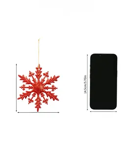 Détail d'un flocon de neige rouge scintillant comparé à la taille d'un smartphone