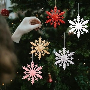 Détail de flocons de neige scintillants colorés accrochés à un sapin de Noël vert festif