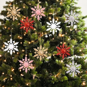 Gros plan d'ornements flocon de neige scintillants colorés suspendus au sapin de Noël