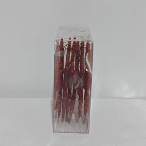 Gros plan d'ornements de Noël glaçons rouge pailleté avec cordons dorés sous emballage