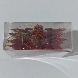 Détail de suspensions sapin de Noël à paillettes rouges dans une boîte avec cordons dorés