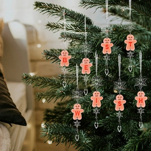 Detailed view of clear acrylic gingerbread man ornaments hanging on a Christmas tree