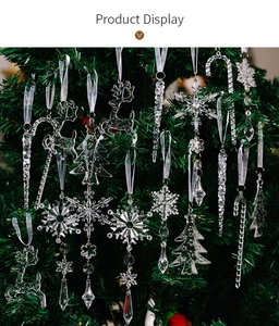 Detailed view of clear acrylic snowflakes and reindeer hanging on a green Christmas tree