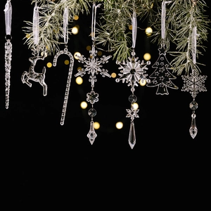 Macro detail of clear acrylic Christmas snowflake and reindeer ornaments with silk ribbons