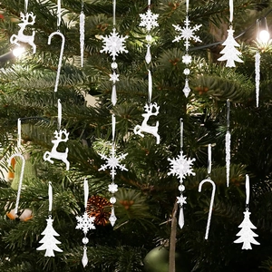 Close-up of transparent acrylic snowflake and reindeer ornaments on a Christmas tree