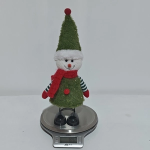 Detailed view of festive snowman plush ornament being weighed on a digital scale