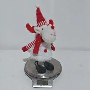Detailed view of a white Christmas moose plush toy on an electronic scale weighing 86 grams