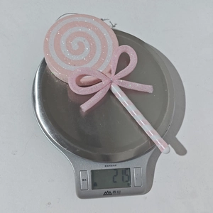 Pink and white glitter candy lollipop ornament with bow weighing 21.5g on a digital scale