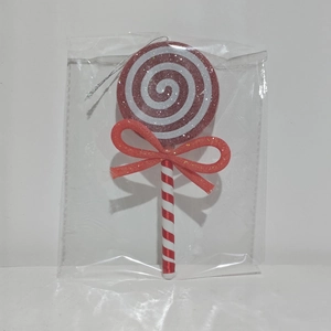 Detail of red and white spiral Christmas lollipop ornament with glitter and a red bow