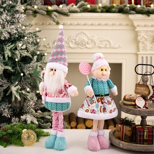 Detail of pink and cyan plush Christmas gnomes with knitted textures on festive fireplace