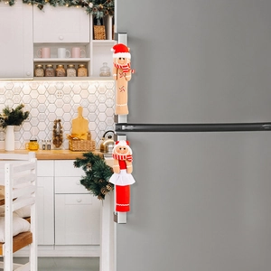 Detail of gingerbread man and woman plush refrigerator handle covers in a modern kitchen