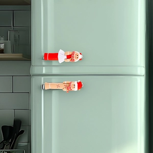 Detail of gingerbread man Christmas fridge handle covers on a retro green refrigerator