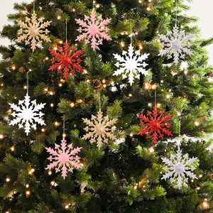 Flocons de neige 3D colorés pailletés suspendus sur sapin de Noël avec lumières chaudes
