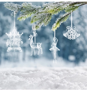 Vista detallada de adornos navideños acrílicos transparentes en una rama de pino