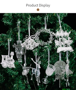 Detalle de adornos navideños de acrílico transparente colgados en un pino verde.