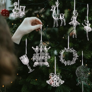 Vista macro de adornos navideños de acrílico transparente con renos y campanas en el árbol