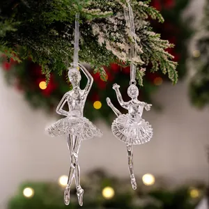 Detail van transparante acryl ballerina-ornamenten aan besneeuwde kerstboomtakken