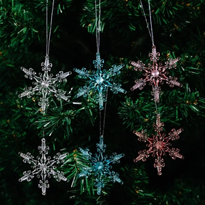 Close-up of 6-piece acrylic snowflake ornaments in clear, blue, and pink on a tree